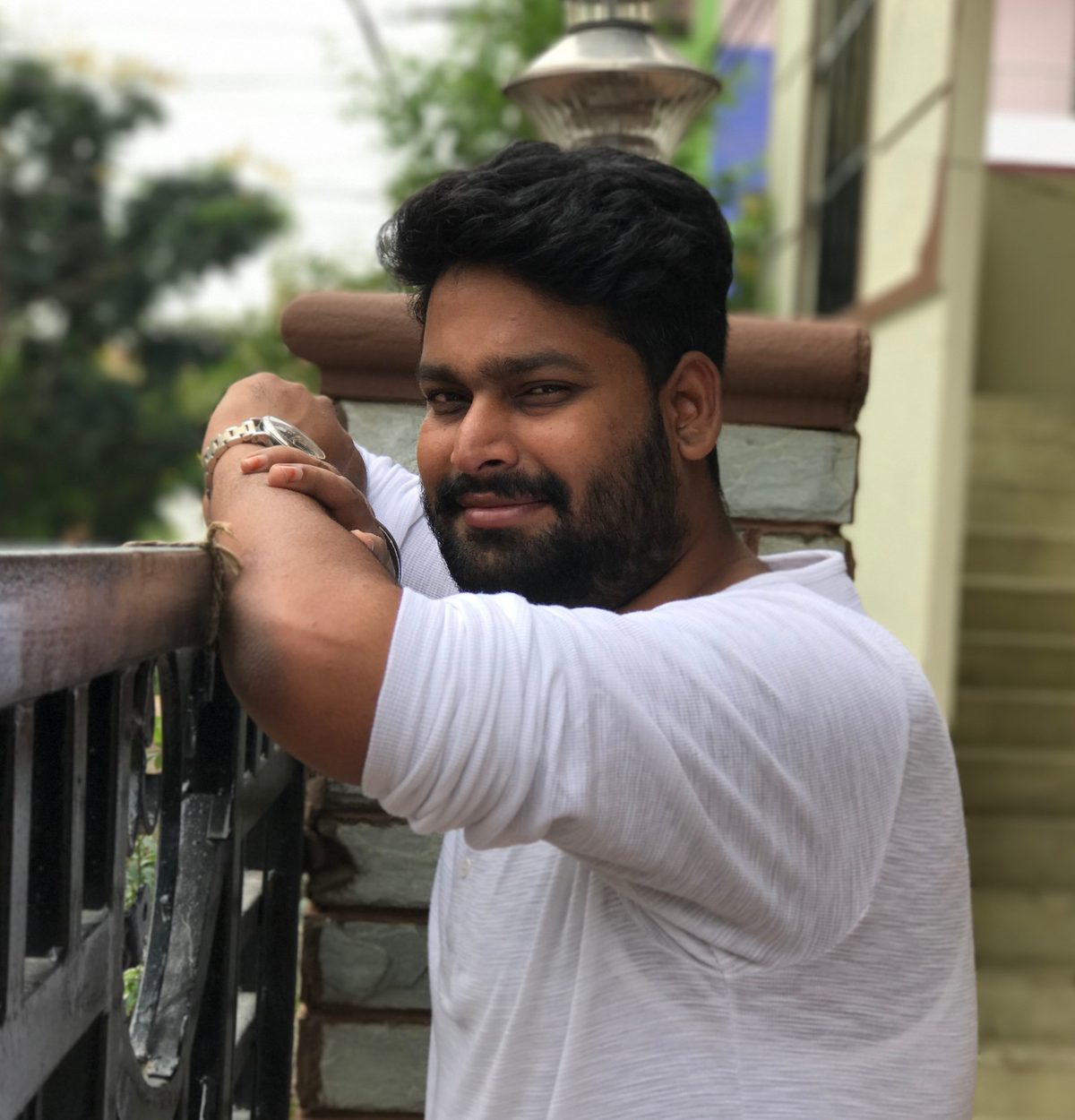 Sashank, smiling, in a white t-shirt outdoors